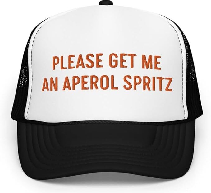black-and-white-trucker-hat-that-says-please-get-me-an-aperol-spritz-in-orange-lettering